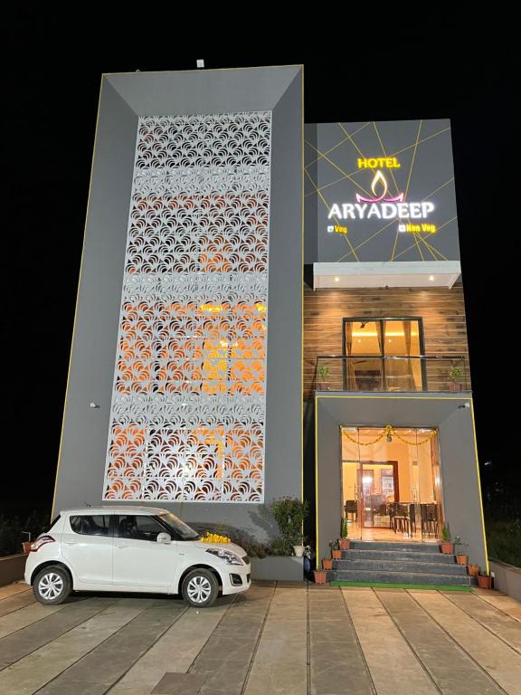 un coche blanco estacionado frente a un edificio en Hotel Aryadeep en Phardāpur