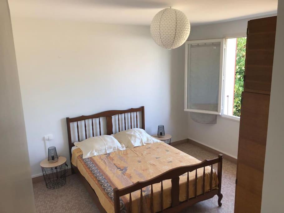 a bedroom with a wooden bed with a window at Maison à 500 mètres de la plage in Saint-Trojan-les-Bains