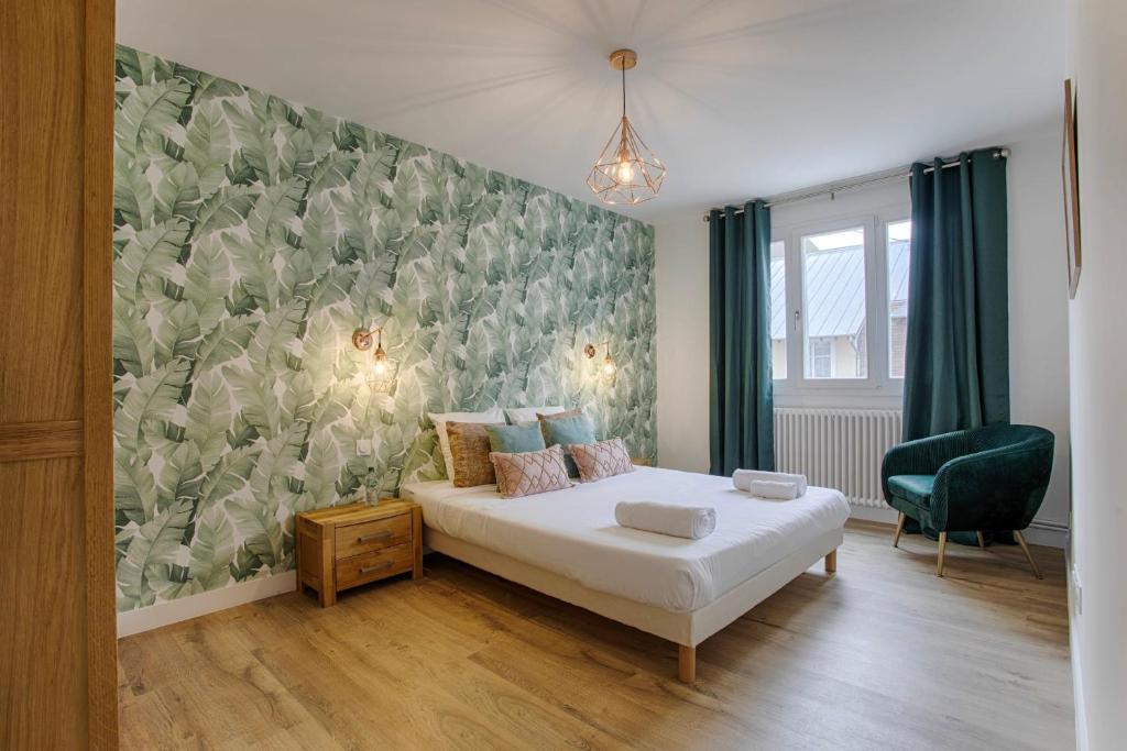 a bedroom with a bed and a green wall at Les Caravelles - Trois Pièces - Deauville Centre in Deauville