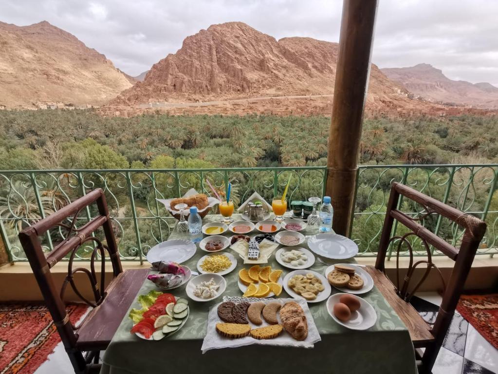 a table with food on it with mountains in the background at Guesthouse Panorama Todra in Tinerhir