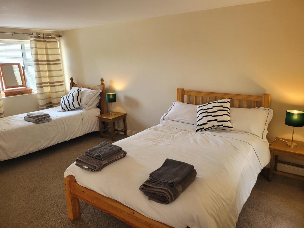 a bedroom with two beds with towels on them at Stoneyford Village in Stonyford