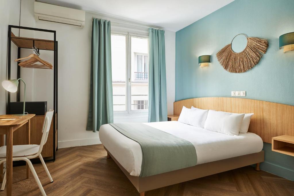 1 dormitorio con cama, escritorio y ventana en Hôtel Kabanel by Happyculture en París