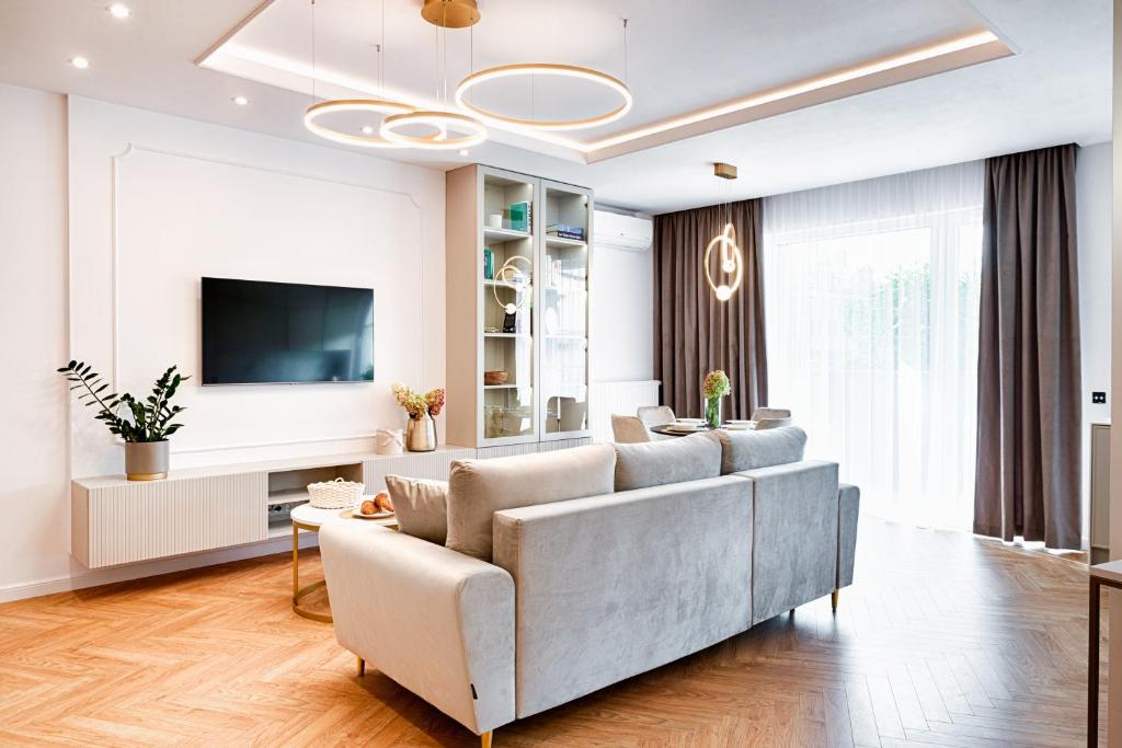 uma sala de estar com um sofá e uma televisão em Wyjątkowy Taupe Apartament w centrum Łodzi em Lódź