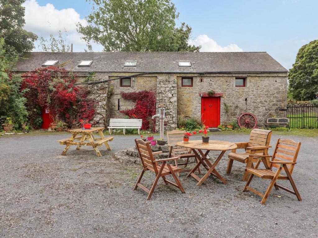 a picnic table and chairs in front of a stone building at Ryan's Loft in Ardfinnan