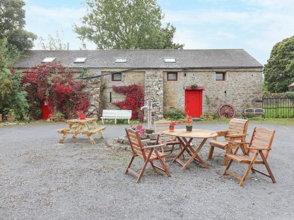 a picnic table and chairs in front of a building at Mrs Delaney's Loft in Ardfinnan
