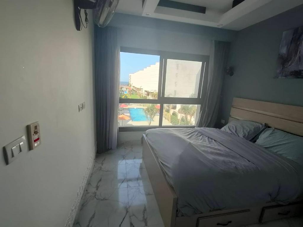 a bedroom with a bed and a large window at Porto Said chalet شاليه بورتو سعيد ثلاث غرف in Port Said