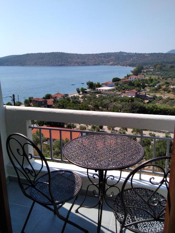 a table and chairs on a balcony with a view of the water at Kamares View (Γαλήνη) in Ayeranós