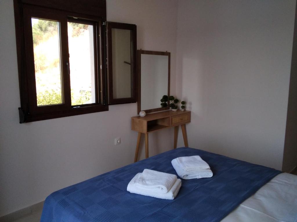 een slaapkamer met een bed met twee handdoeken erop bij Kamares View (Γαλήνη) in Ayeranós
