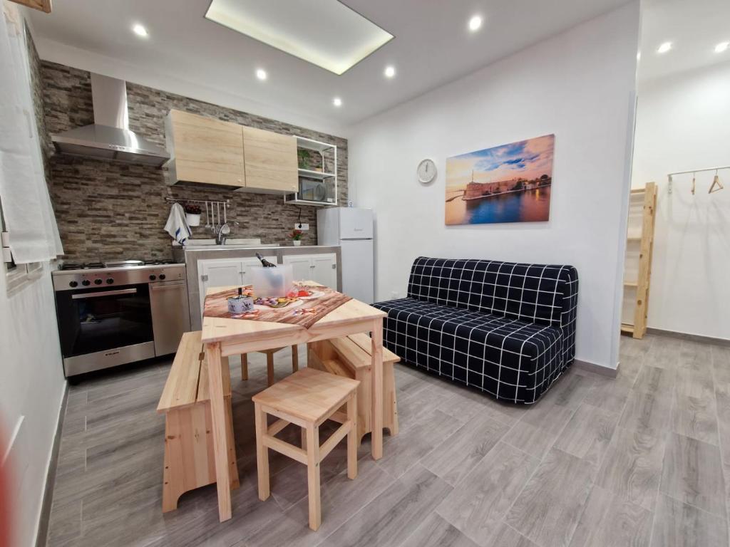 eine Küche und ein Wohnzimmer mit einem Tisch und einem Sofa in der Unterkunft La casa di Teresa in Taranto