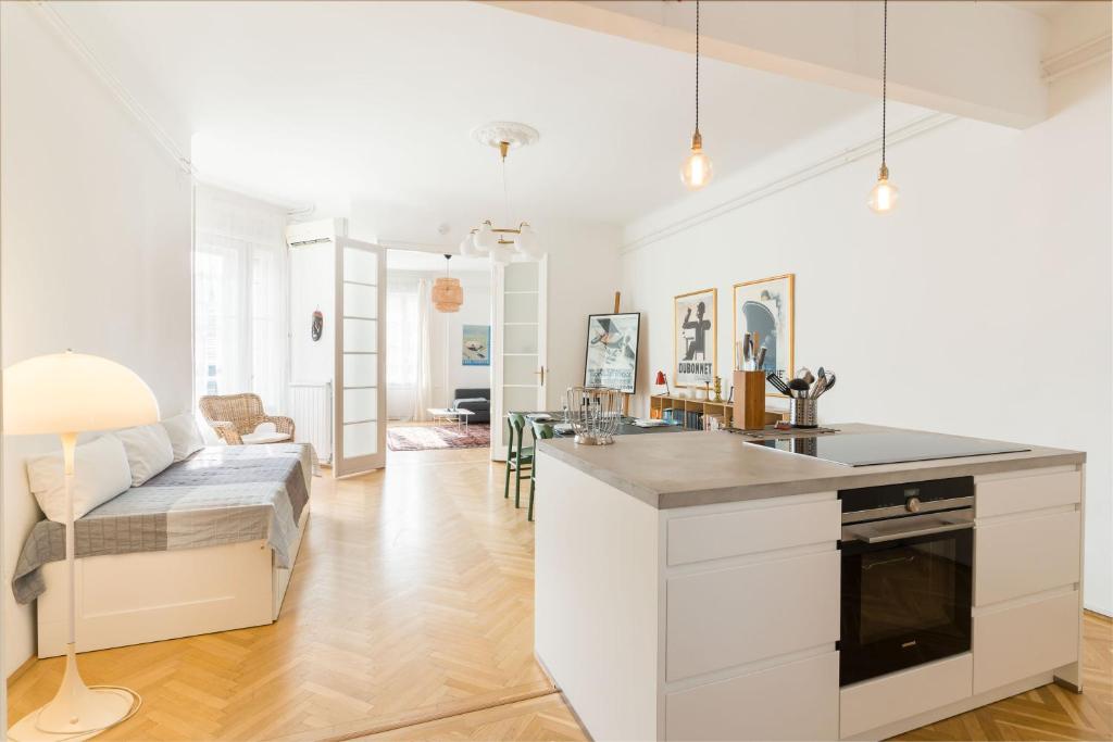una cucina e un soggiorno con divano e tavolo di Klauzal apartment w/3 bedrooms, french balcony a Budapest