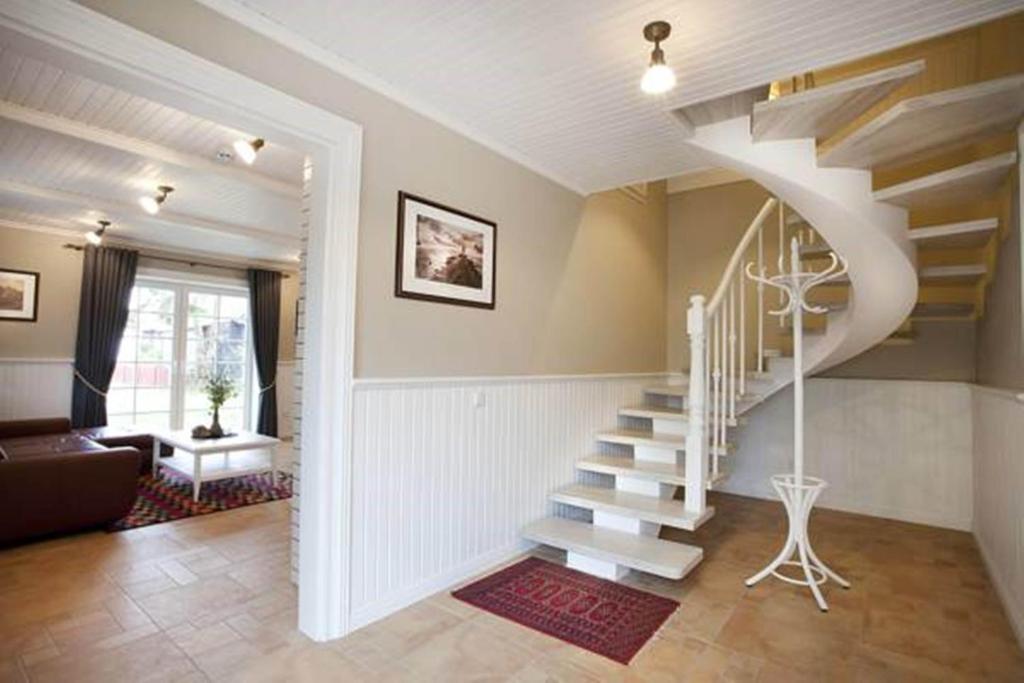- un salon avec un escalier en colimaçon dans une maison dans l'établissement Vila Pervalka, à Pervalka