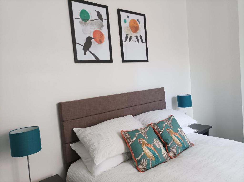 a bedroom with a bed with three pictures on the wall at Victorian Renovation Room 4 in Liverpool