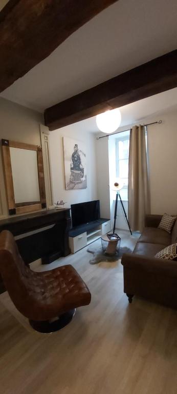 uma sala de estar com um sofá e uma cadeira em La Fabrique em Bourg-en-Bresse