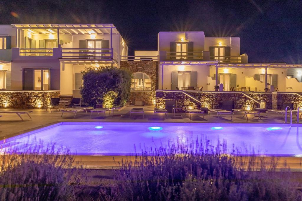 a villa with a swimming pool at night at Sea Wind Villas and Suites in Tourlos