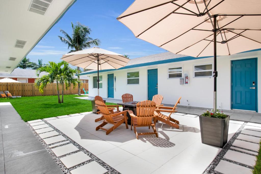 eine Terrasse mit einem Tisch, Stühlen und Sonnenschirmen in der Unterkunft LoKal Rental Tropical Florida destination in Fort Lauderdale