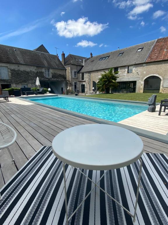 a patio with a white table and a swimming pool at VILLA MARLISE Chambre Hôtes in Saint-Satur
