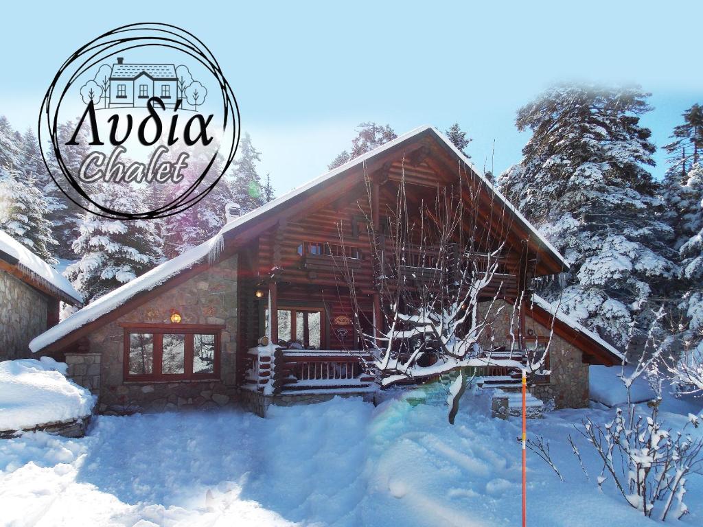 a log cabin in the snow with the apollo chalet logo at Mouses Chalet Lydia Επτάλοφος Παρνασσού in Eptalofos
