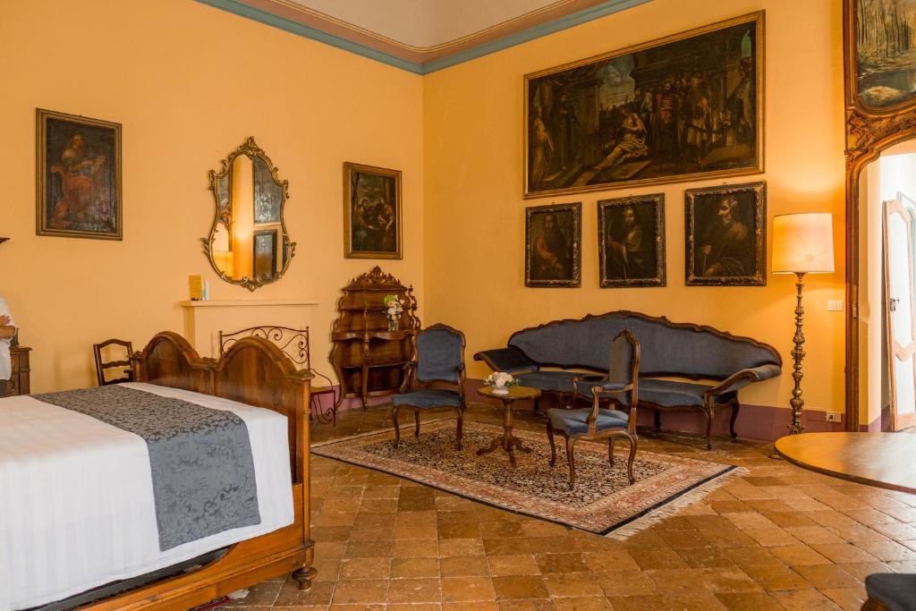a bedroom with a bed and a table and chairs at Albergo Real Castello in Verduno