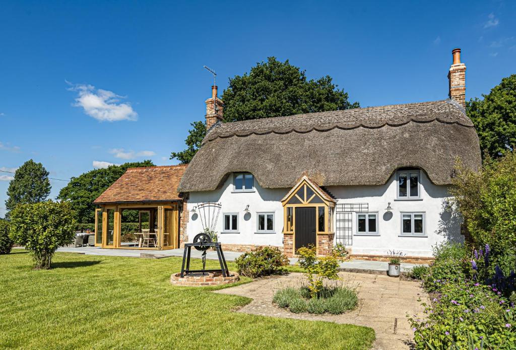 a large white house with a thatched roof at Hilltop Cottage in Chalbury