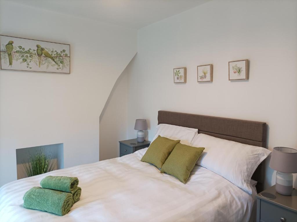 a bedroom with a white bed with two green pillows at Victorian Renovation Room 5 in Liverpool