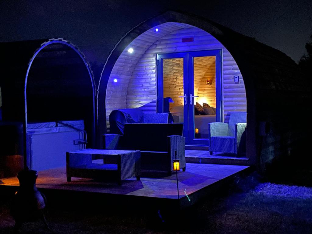 a dark room with a couch and chairs in a tent at Little Meadow Pods with Hot Tub in York