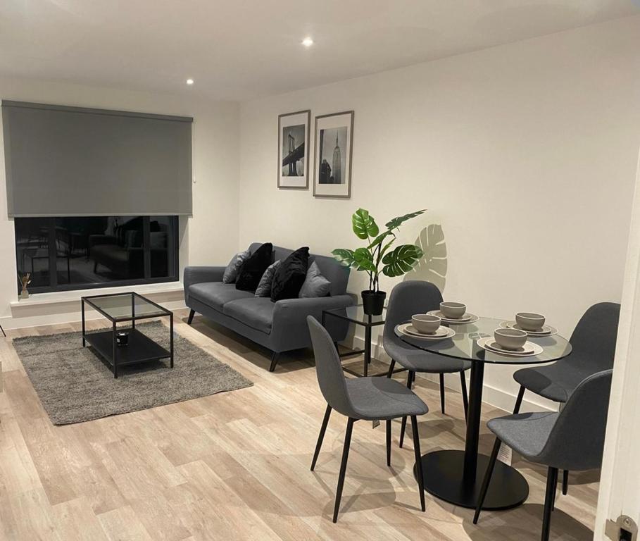 a living room with a couch and a table and chairs at Stylish Birmingham City Centre Apartment in Birmingham