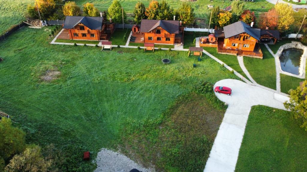 Vue aérienne d'une maison sur un champ verdoyant dans l'établissement La Cabane Râșnov, à Râșnov
