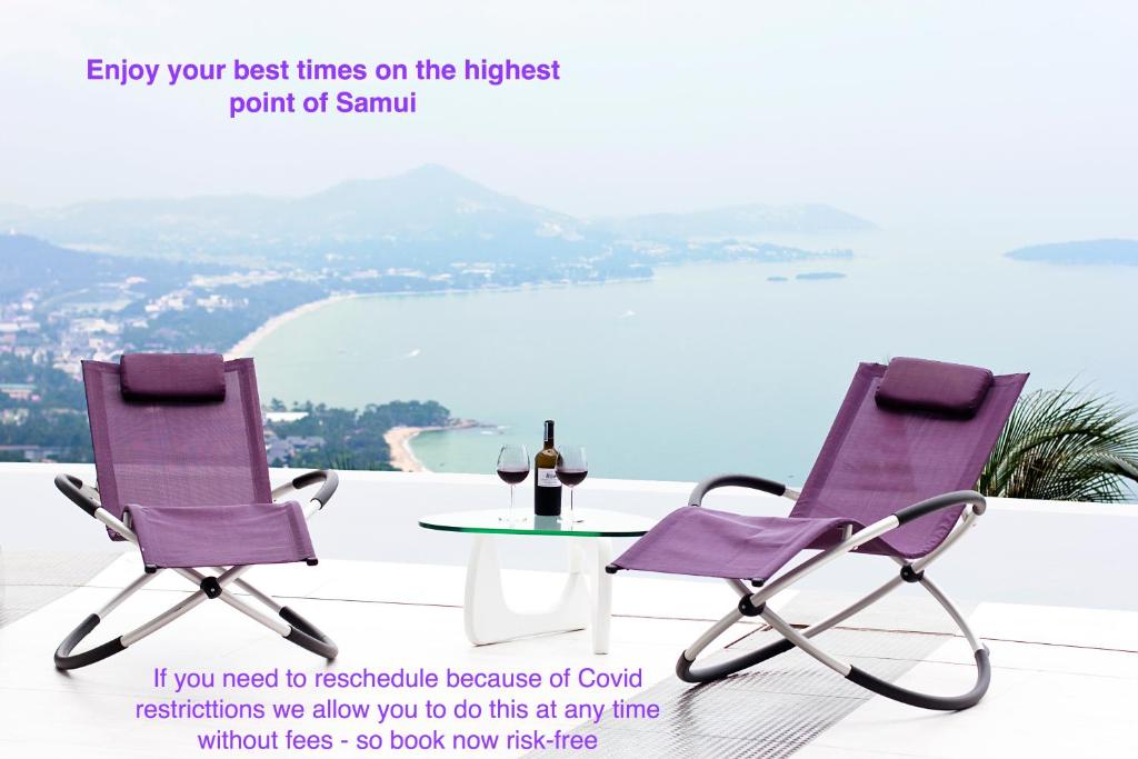 Best world vision في شاطئ تشاوينغ: زوج من الكراسي الأرجوانية وطاولة مع زجاجة من النبيذ