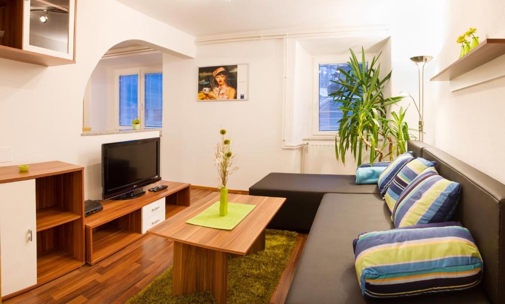 ein Wohnzimmer mit einem Sofa und einem TV in der Unterkunft Apartments Shock in Cerkno
