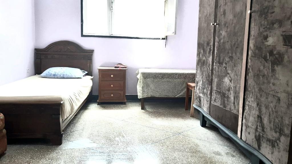 a bedroom with a bed and a dresser and a window at Zitouna Rooms in Casablanca