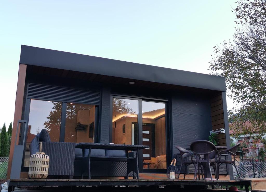 a black tiny house with a table and chairs at EHINACEA in Rtanj