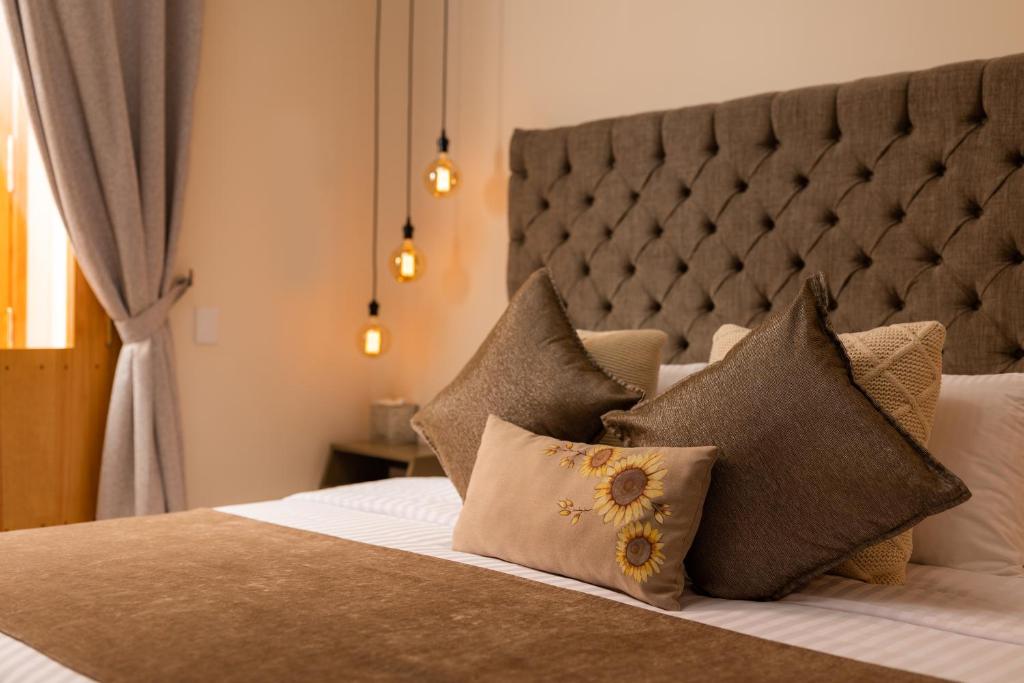 a bedroom with a bed with pillows on it at ArcoSodi Hotel Boutique in Oaxaca City