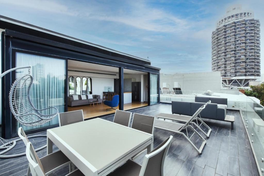 a balcony with a table and chairs on a building at Touch The Sky by HolyGuest in Tel Aviv