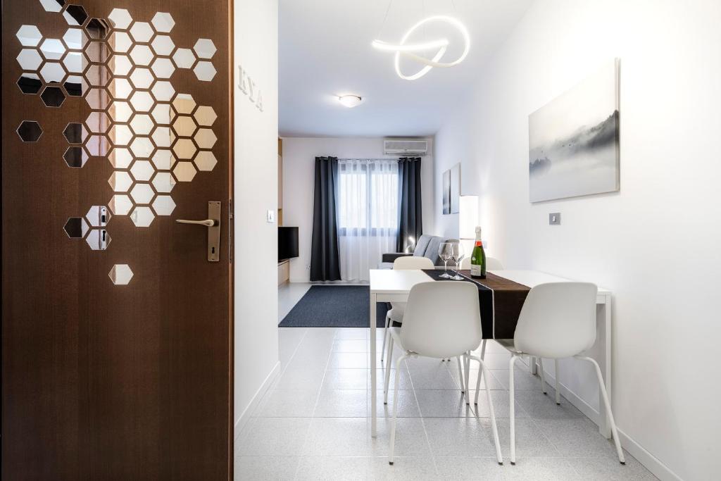 a dining room with a table and white chairs at Kya Venice and Beach House: Venezia, mare e laguna in Cavallino-Treporti