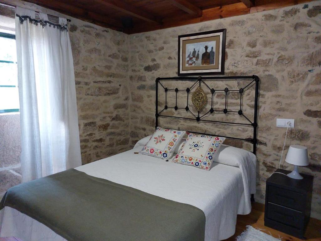 - une chambre avec un lit et des oreillers dans l'établissement Casas de Maragouzos, à Silleda