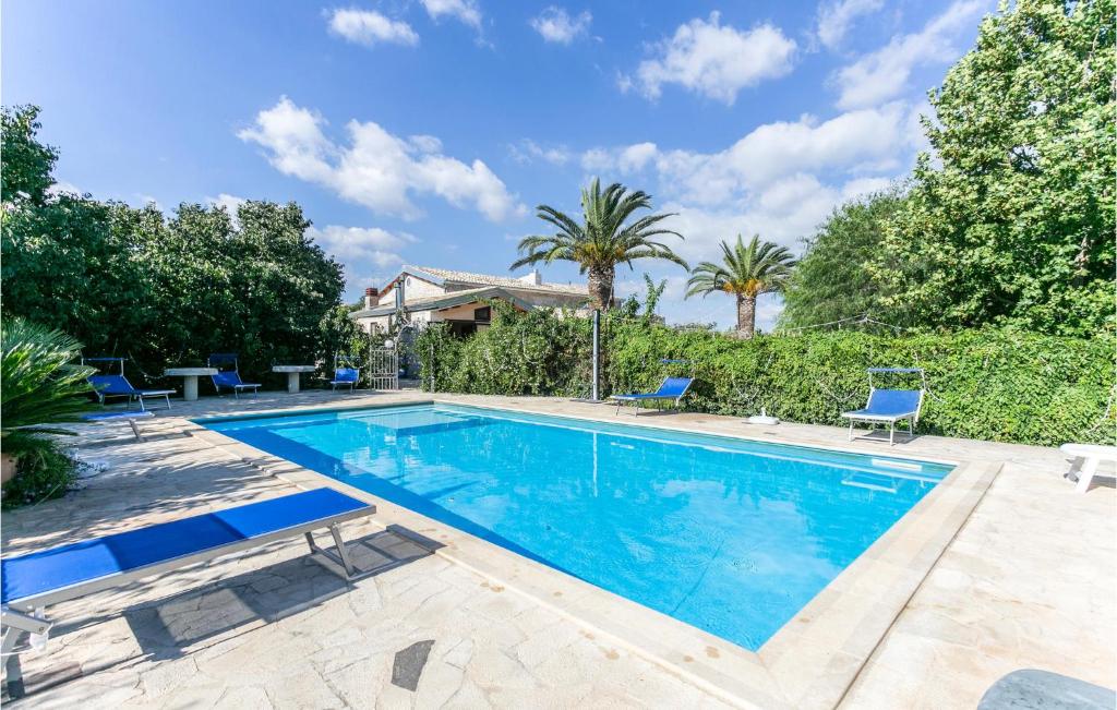una piscina con sillas azules y árboles en Casale Della Contea, en Casa Papa