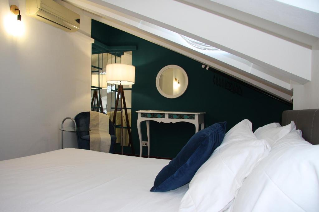 sypialnia z białym łóżkiem i zieloną ścianą w obiekcie Mercanti Attic Version w Mediolanie