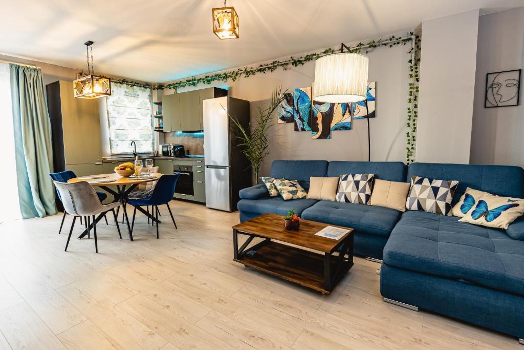 Alice apartment في سيبيو: غرفة معيشة مع أريكة زرقاء وطاولة