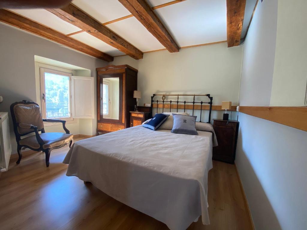 a bedroom with a bed and a chair in it at CASA SENERA in Santa Cruz de la Serós
