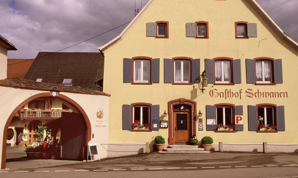 a large yellow building with a sign on it at zum Schwanen Garni in Buggingen