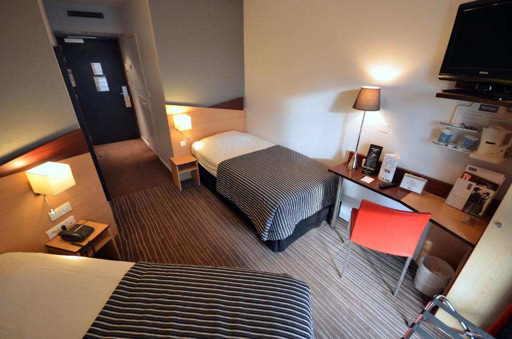 Postel nebo postele na pokoji v ubytování Kyriad Hotel Dijon Gare