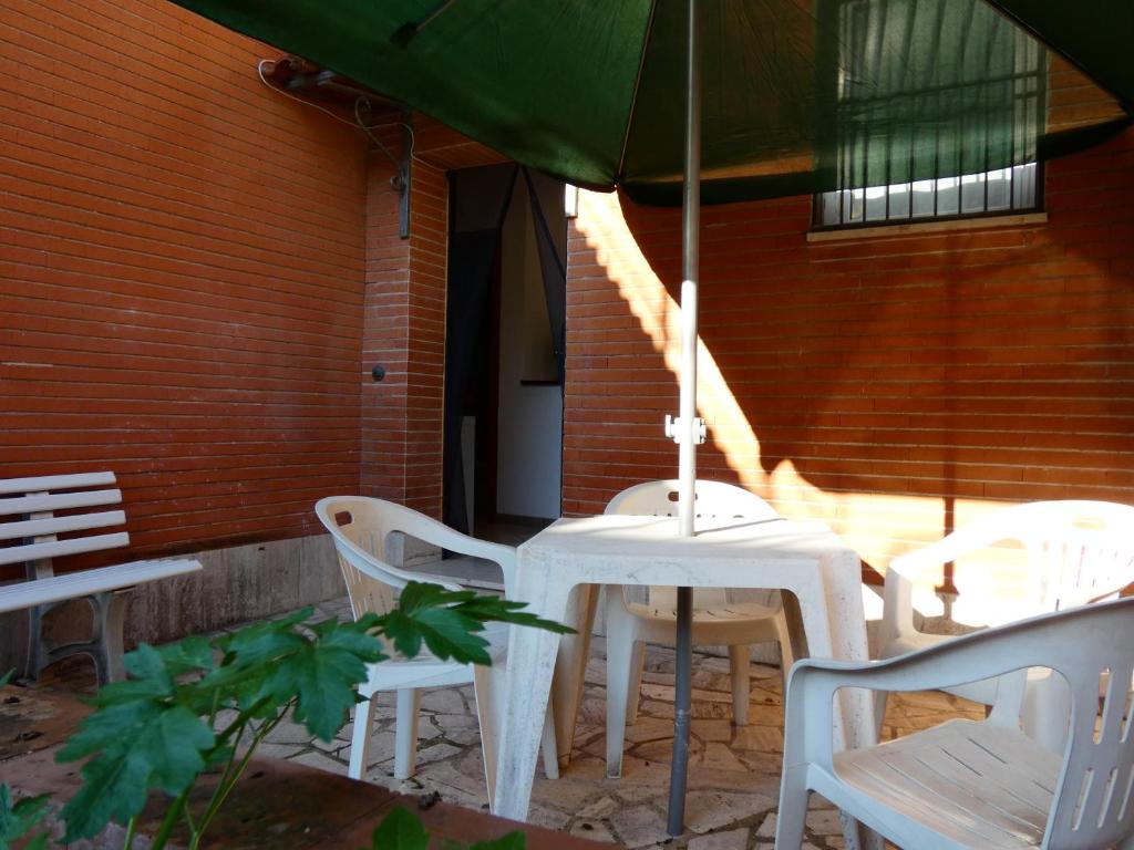 a table and chairs with an umbrella on a patio at Le dimore di Esiodo in Rome