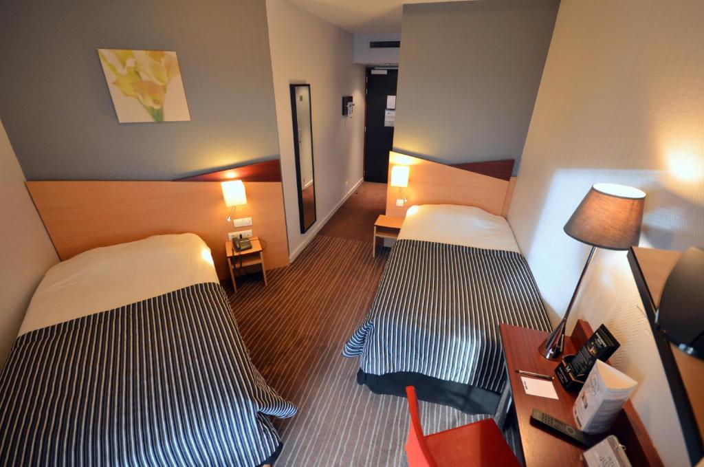 Postel nebo postele na pokoji v ubytování Kyriad Hotel Dijon Gare