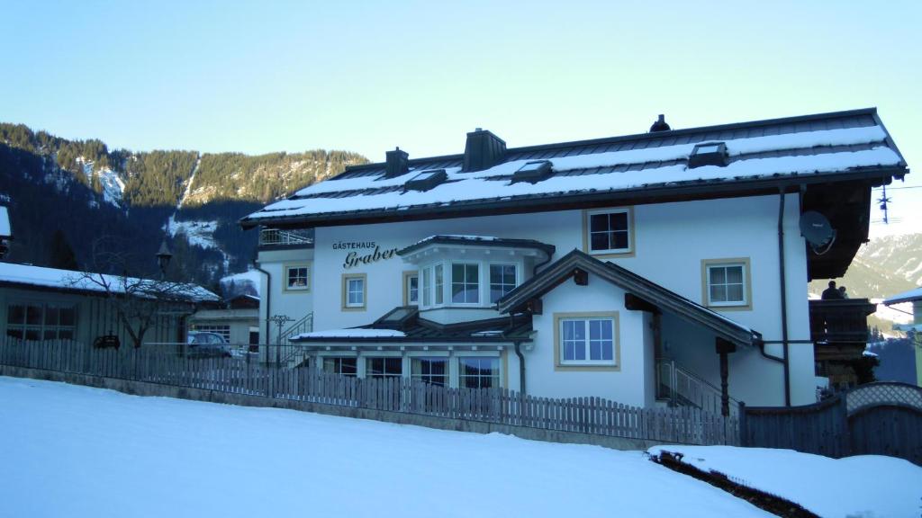 un gran edificio blanco con nieve en el techo en Apartment Graber, en Krimml