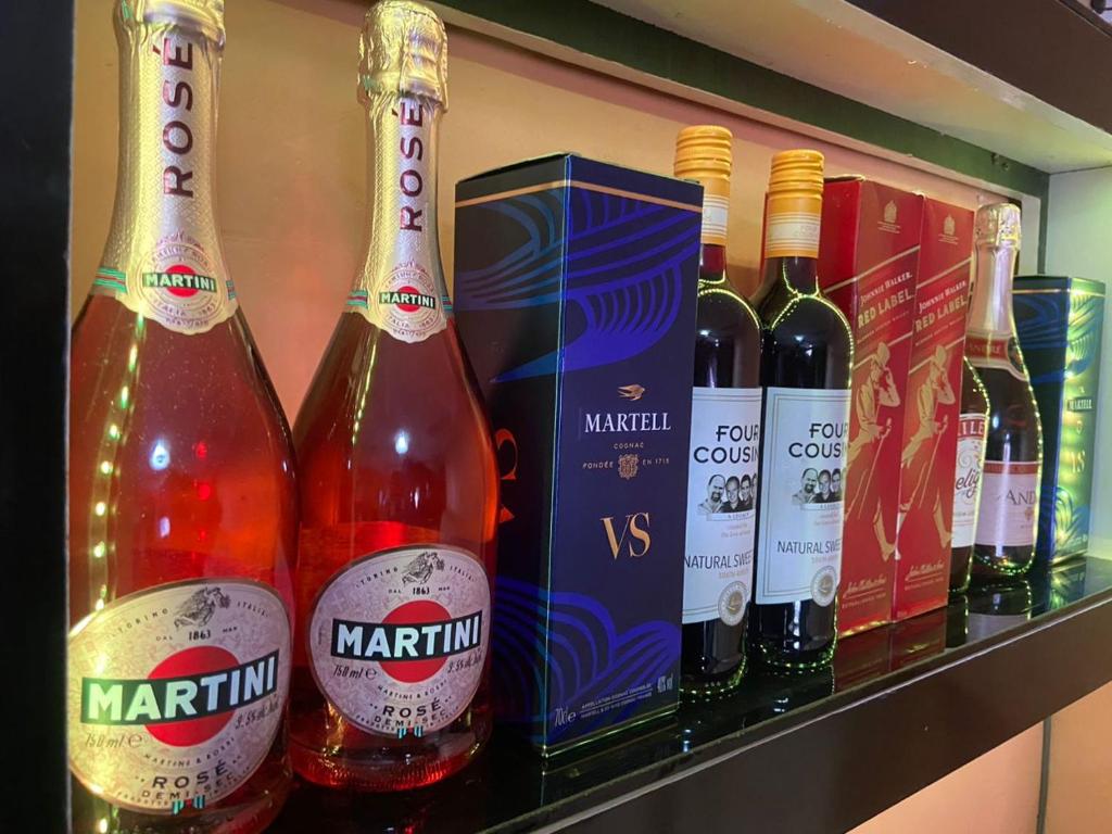 un grupo de botellas de vino en una estantería en Oak Suites & Bar, en Benin City