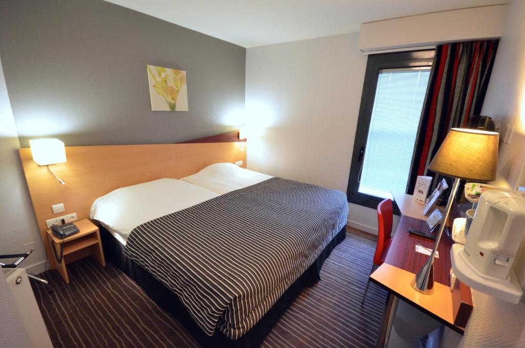 Postel nebo postele na pokoji v ubytování Kyriad Hotel Dijon Gare