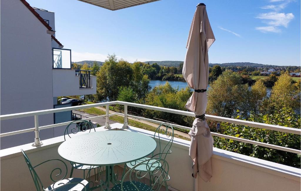 a balcony with a table and an umbrella at Amazing Apartment In Triel-sur-seine With 2 Bedrooms And Wifi in Triel-sur-Seine