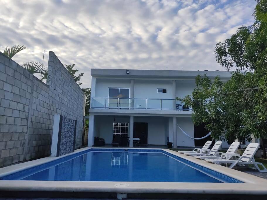 uma casa com piscina em frente a uma casa em CASA DYA em Cozumel