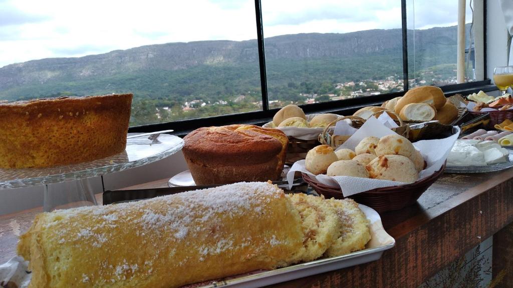 uma mesa com diferentes tipos de bolos e doces em Pouso Flor da serra em Tiradentes