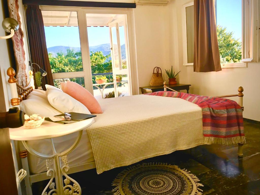 een slaapkamer met een bed met een tafel en een raam bij Theodora Hotel in Petra